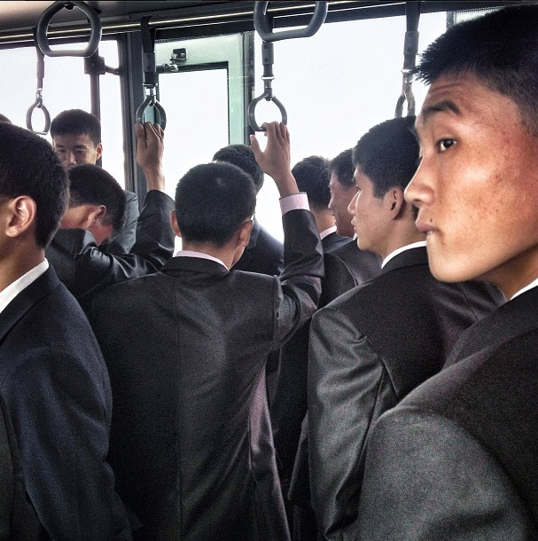 Men on an airport transport bus. Photo credits: David Guttenfelder