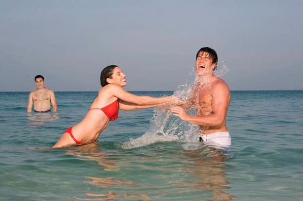 Asia, Thailand, Young Couple in ocean, splashing water